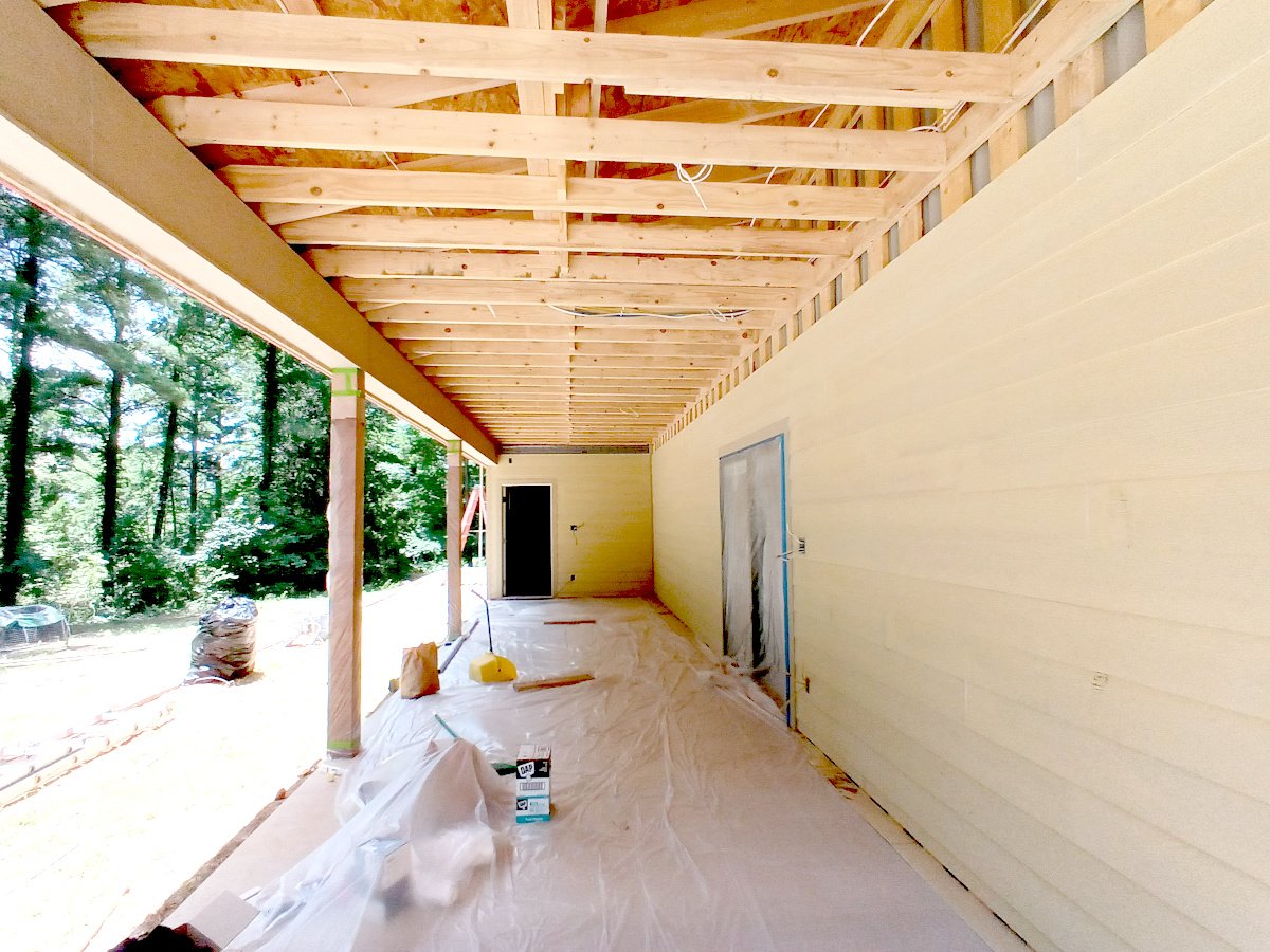 Flooring installation in progress during a porch and bathroom remodeling project in East Texas
